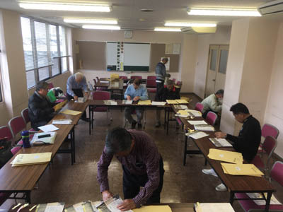 音次郎講演会のチラシを分類する会員ら